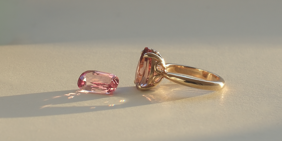 A loose gemstone beside a finished piece