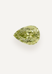 Alternate face up product view showing pale yellow green in a tapered drop with scattered dark marks.