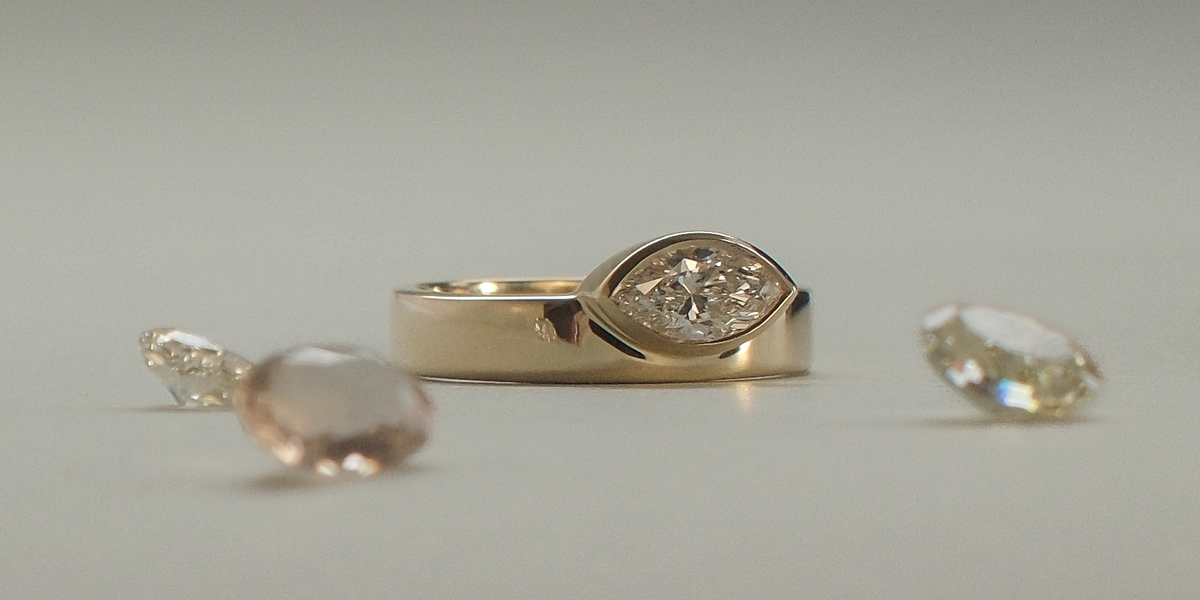 Gold ring and loose stones in a still-life arrangement