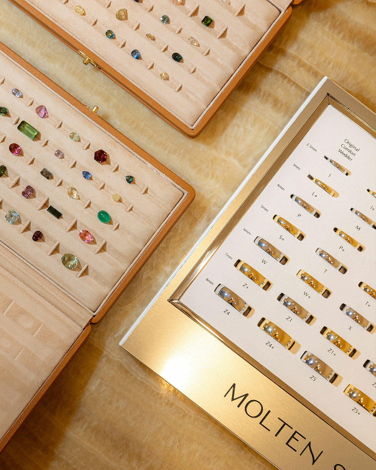 Gemstones and wedding bands in trays