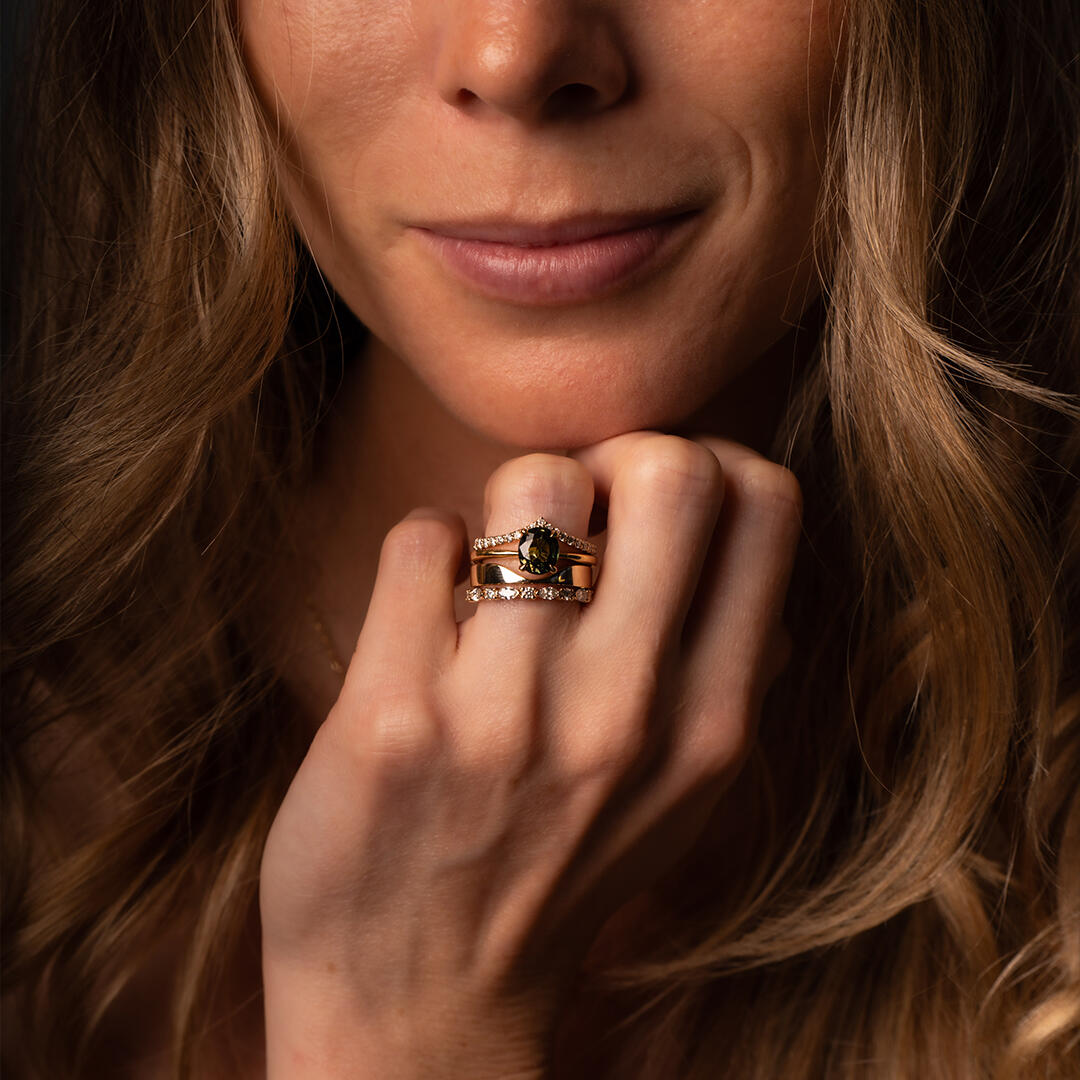 Image of an engagement ring with an oval centre stone and 3 side stones on each side scaling down